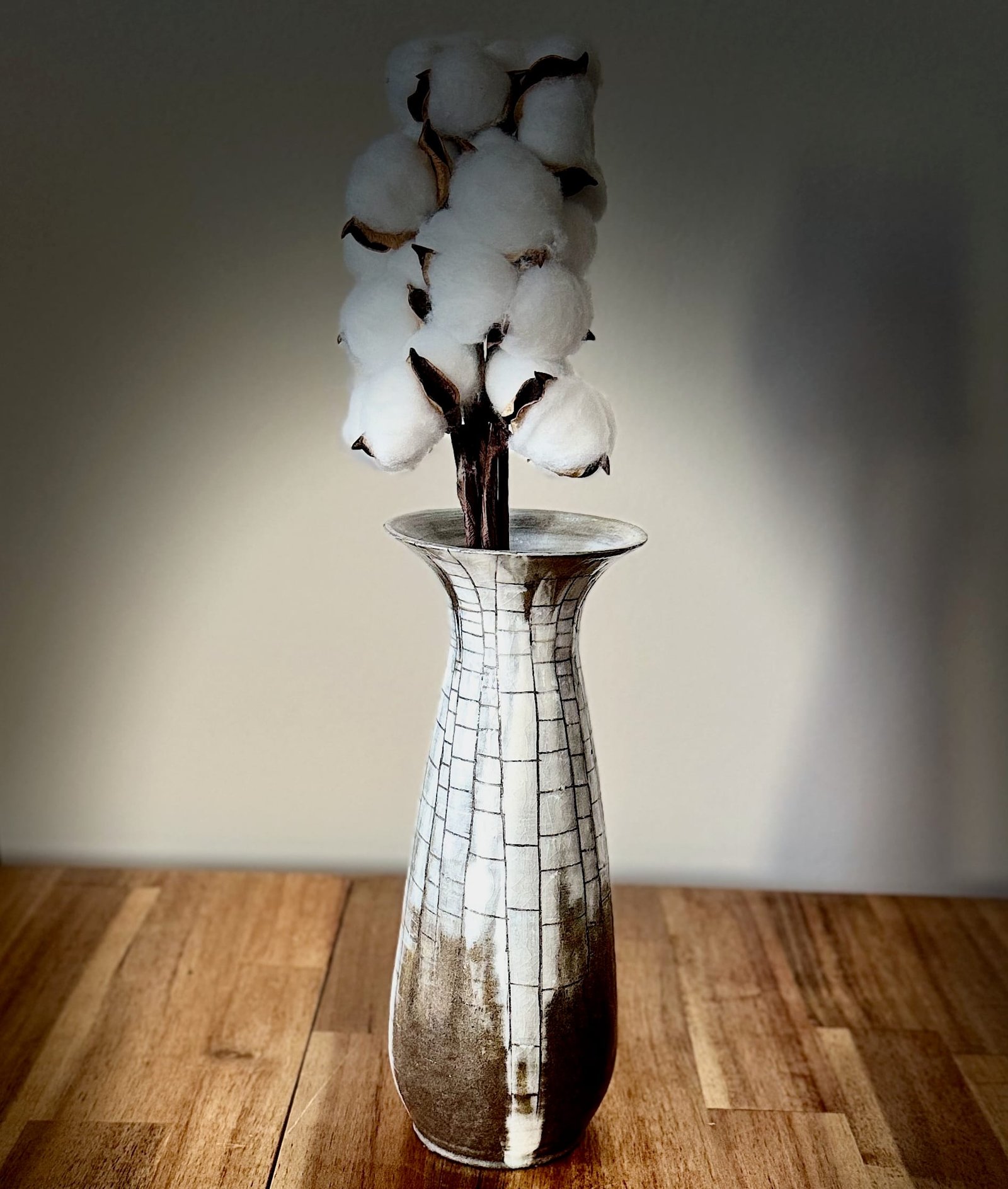 Vase en céramique (grès) contenant une tige de fleur de coton